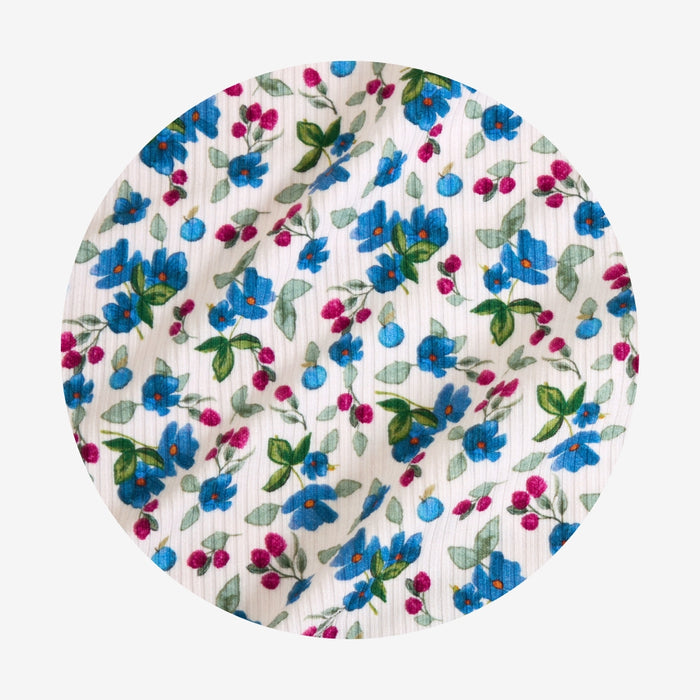 Floral-patterned fabric with blue, pink, and green flowers on a white background