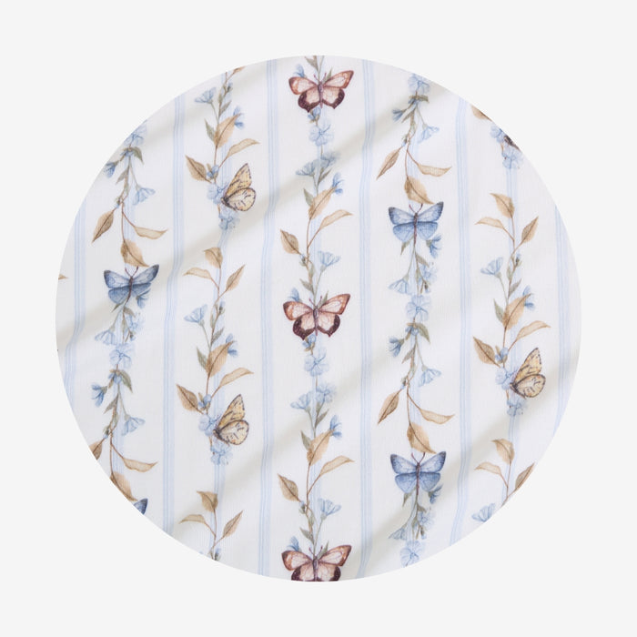Round fabric swaddle with butterfly and floral pattern on a white background