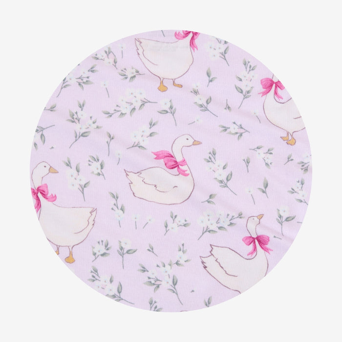 Round fabric swatch with goose pattern on a light purple background