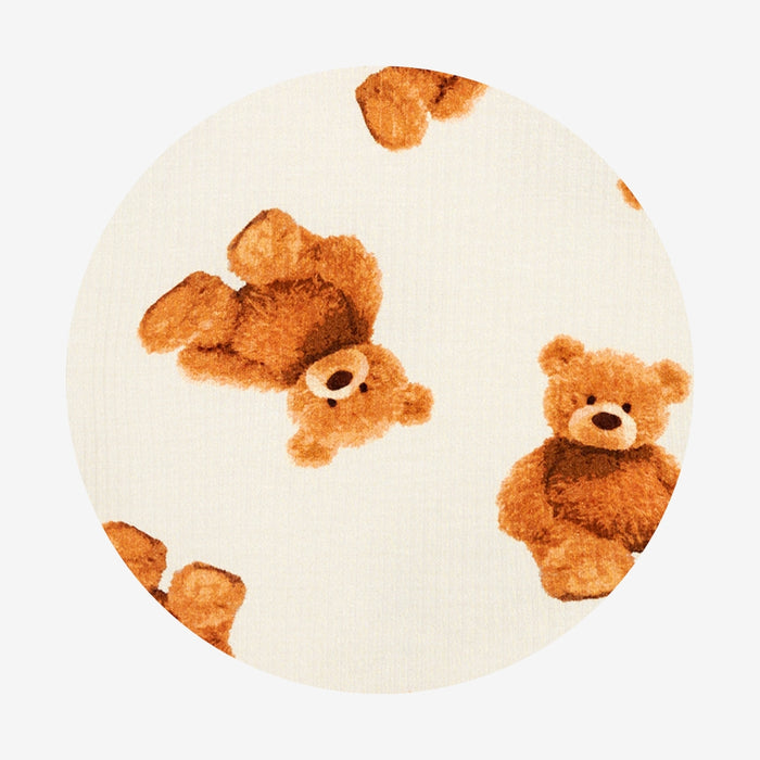 Round white fabric swatch with teddy bear design on a white background