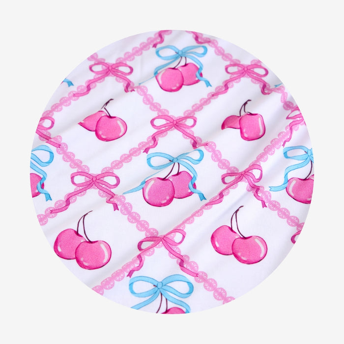 Circular product with cherry and bow pattern on a white background