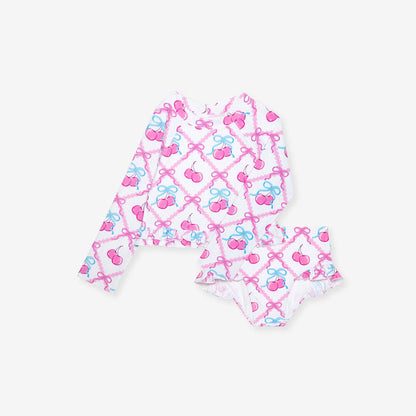 Children's swimsuit with pink and blue bow pattern on a white background