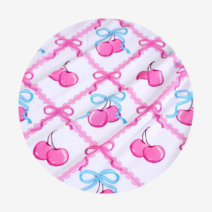 Circular product with cherry and bow pattern on a white background