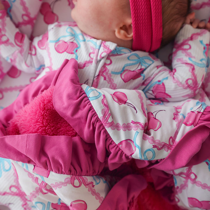Close-up of a baby in pink and white outfit with bow pattern