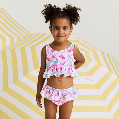 Young girl wearing a colorful swimsuit with a geometric yellow and white background