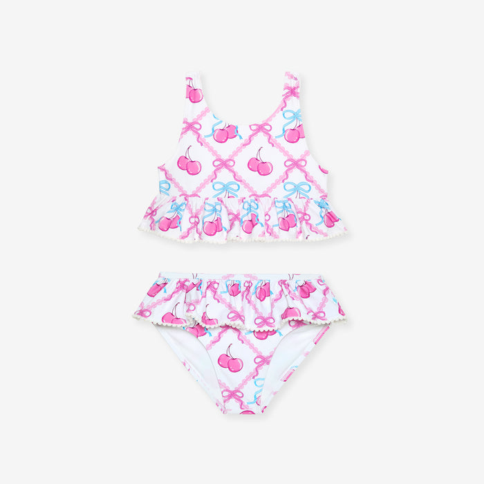 Two-piece swimsuit with cherry and bow pattern on a white background