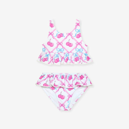 Two-piece swimsuit with cherry and bow pattern on a white background