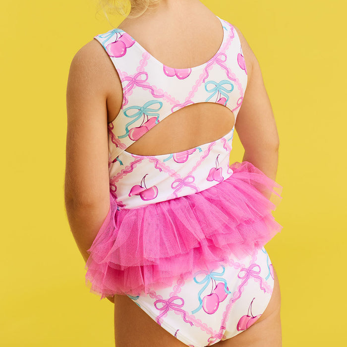 Child wearing a colorful swimsuit with a tutu on a yellow background