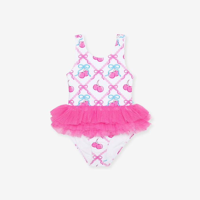 Children's swimsuit with pink tutu and cherry pattern on a white background