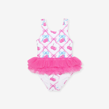 Children's swimsuit with pink tutu and cherry pattern on a white background