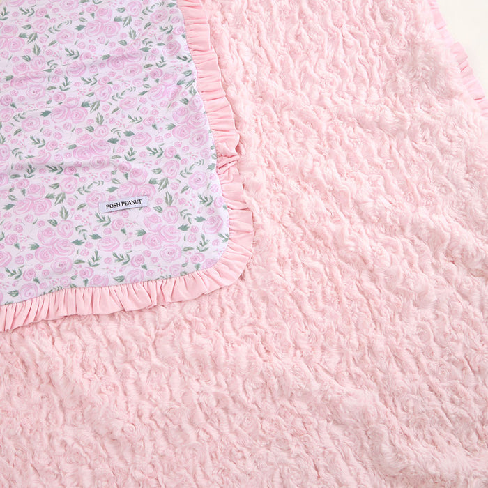 Pink textured blanket with floral border and 'Posh Peanut' label.