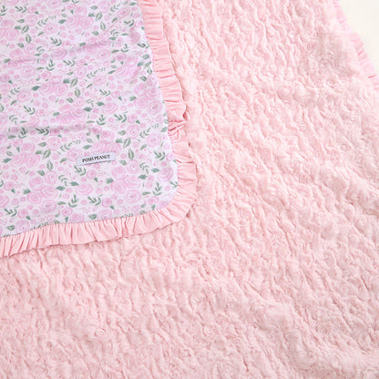 Pink textured blanket with floral border and 'Posh Peanut' label.