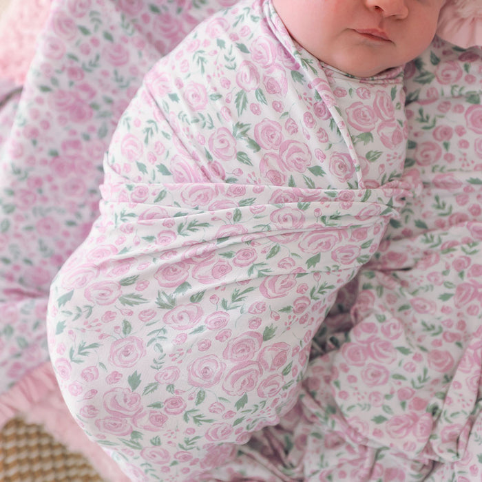 Baby swaddled in a matching pink floral blanket
