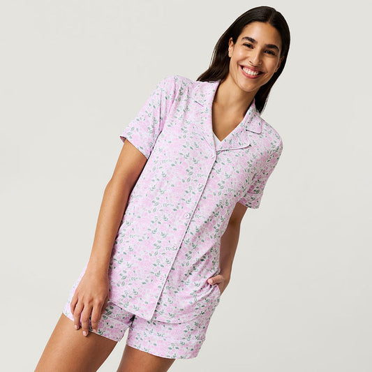 Woman wearing rose printed short pajama set on a white background.