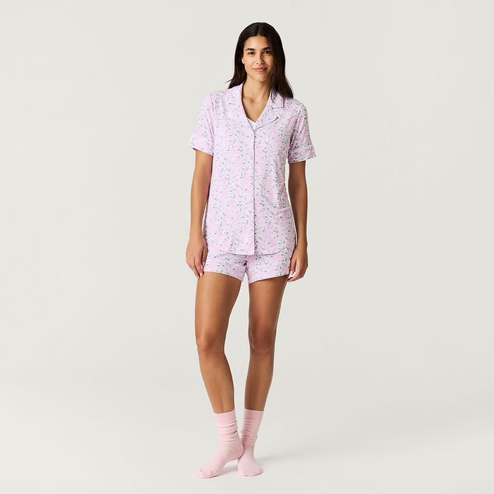 Woman wearing a rose printed short pajama set on a white background.