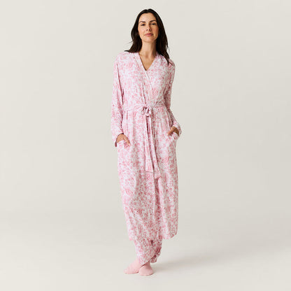 Woman wearing a pink floral robe on a plain background