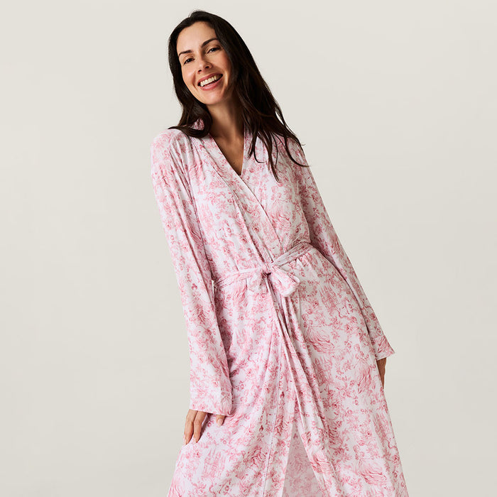 Woman wearing a pink floral robe against a plain background