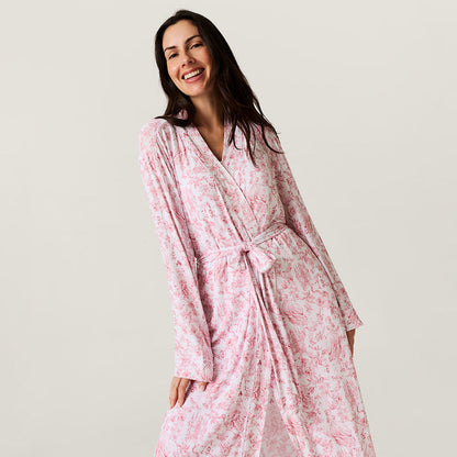 Woman wearing a pink floral robe against a plain background
