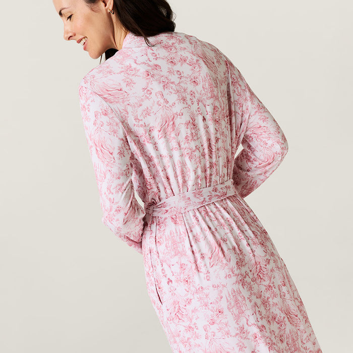 Woman wearing a pink floral robe against a plain background