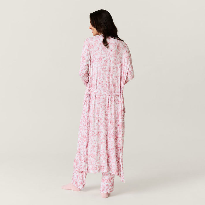 Woman wearing a pink floral pajama set on a plain background