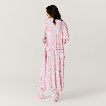 Woman wearing a pink floral pajama set on a plain background