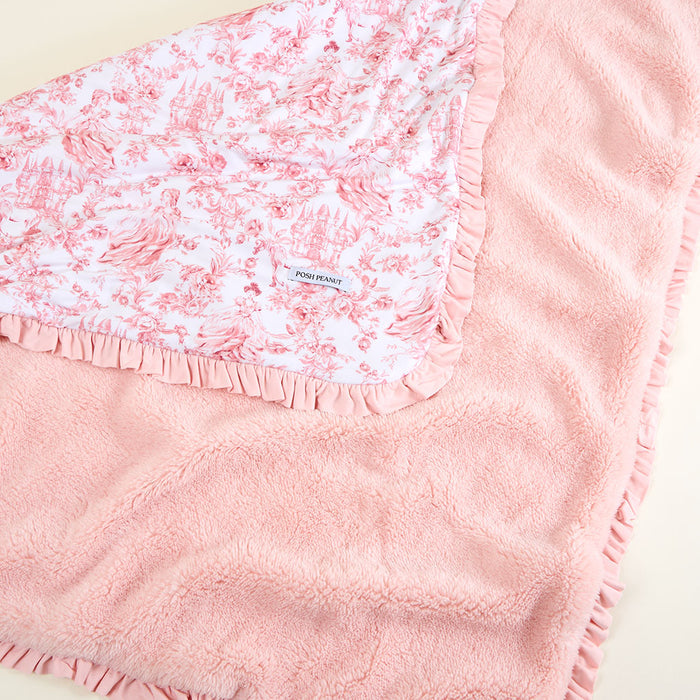 Pink floral blanket with a visible brand logo on a light background