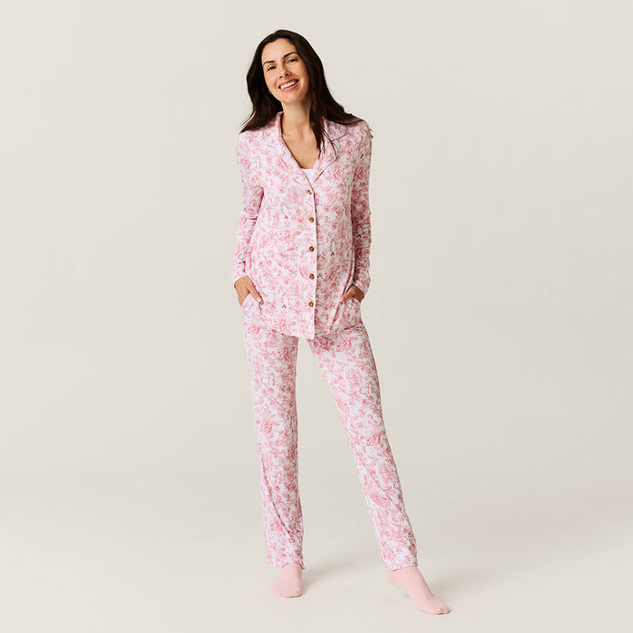 Woman wearing pink floral pajamas on a plain background