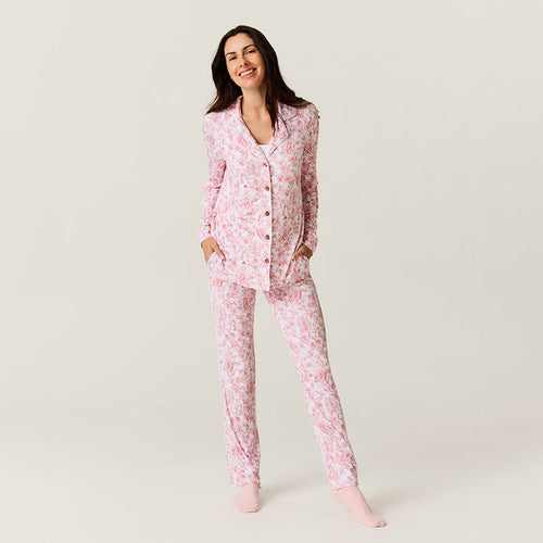 Woman wearing pink floral pajamas on a plain background