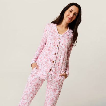 Woman wearing pink floral pajamas against a plain background