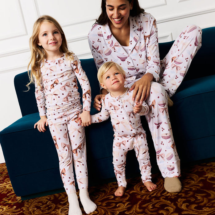 Woman and two children in matching pajamas sitting on a blue couch.