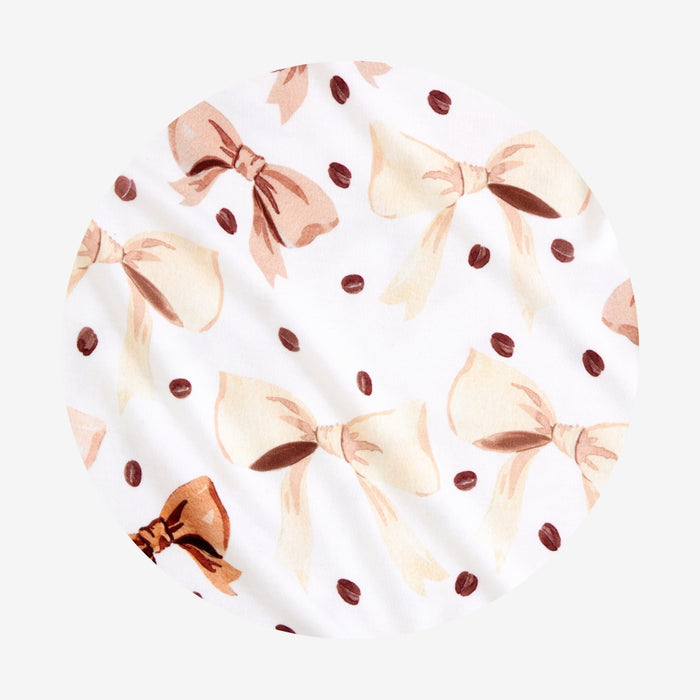 Fabric swatch with coffee beans and bow pattern on a white background