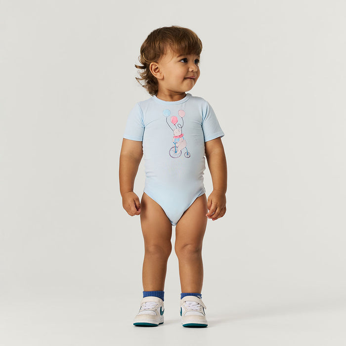 Child wearing a light blue bodysuit with a design on a plain background
