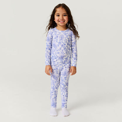 Young girl wearing a blue floral pajama set on a white background