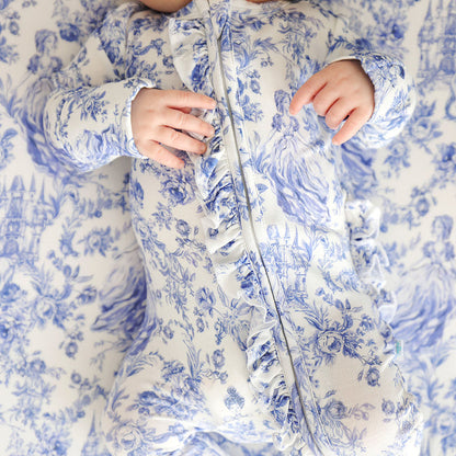 Baby wearing a blue printed one piece showing a detail of the rufflec zipper detail