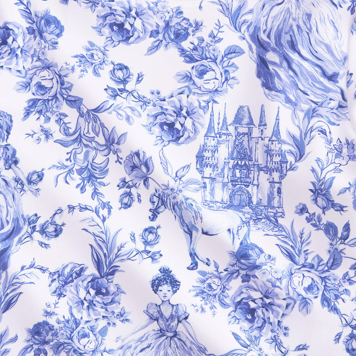 closeup showing blue and white whimsy print with castles, horses, flowers and woman in dress