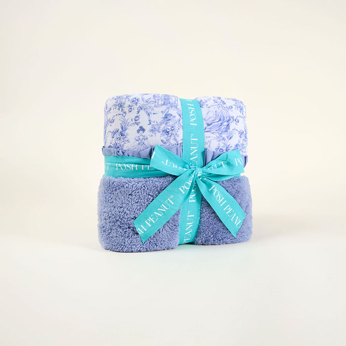 Folded blue blanket with a turquoise ribbon on a white background