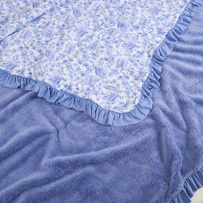 Blue floral fabric with ruffled edge on a textured blue surface