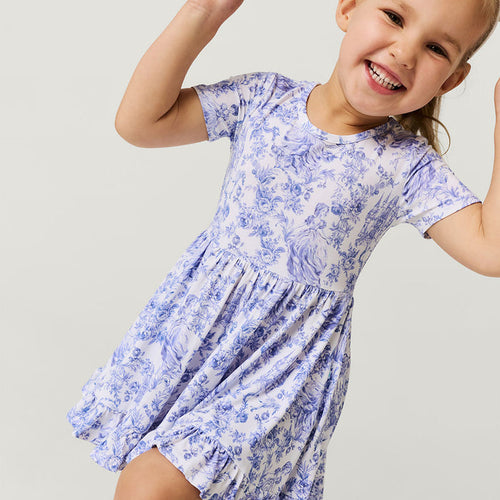 Child wearing a blue floral dress on a light gray background