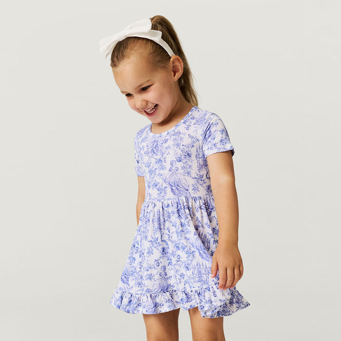 Young girl wearing a blue floral dress on a light gray background