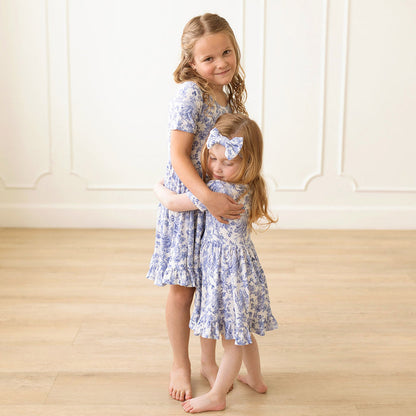 Two girls with matching blue floral dresses