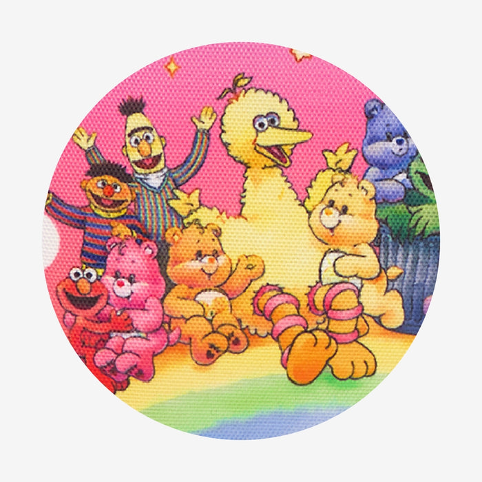 Circular patch with colorful Sesame Street and Care Bear characters on a pink background