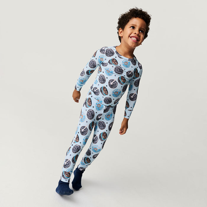Child wearing a patterned one piece on a plain background