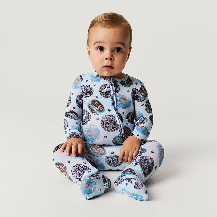 baby wearing blue one piece with caviar print