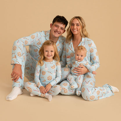 Family of four wearing matching pajamas with a cookie pattern on a beige background