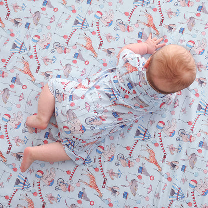 Laying laying on a blanket wearing a matching circus print henley shortall