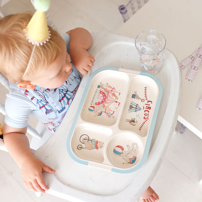 Child in a high chair with a circus-themed tray