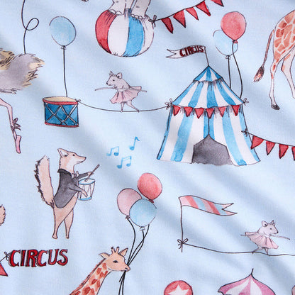 Fabric with circus-themed design featuring animals and circus elements on a light blue background.