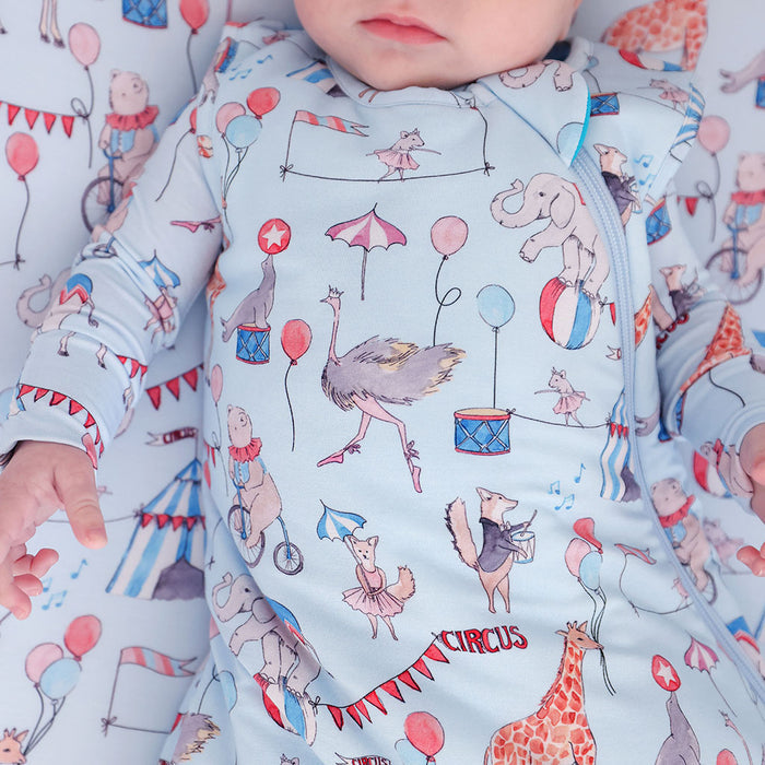 close up image of baby in a sleeveless sleep bag with circus print.