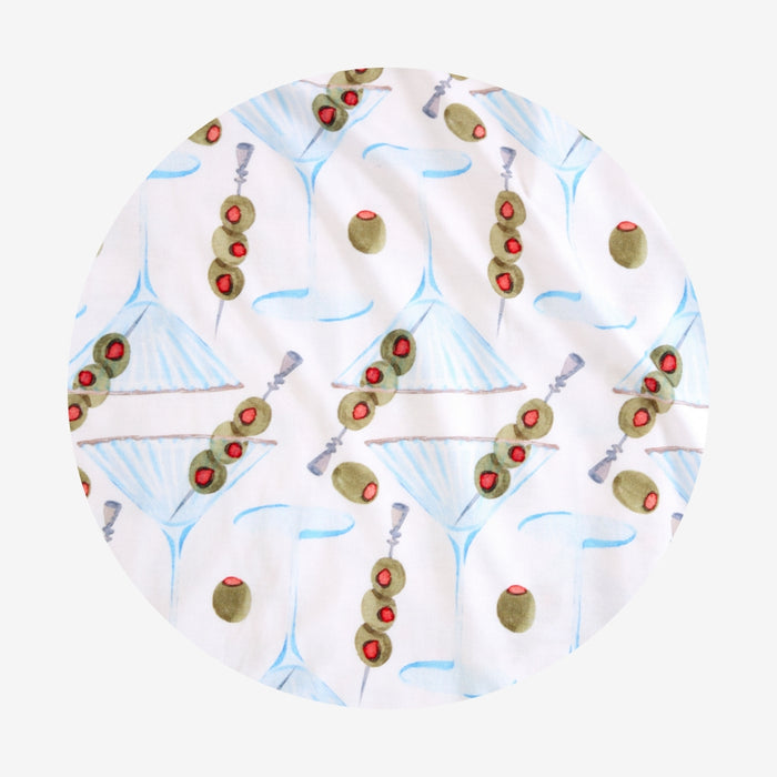 Round fabric swatch with olive and martini pattern on a white background