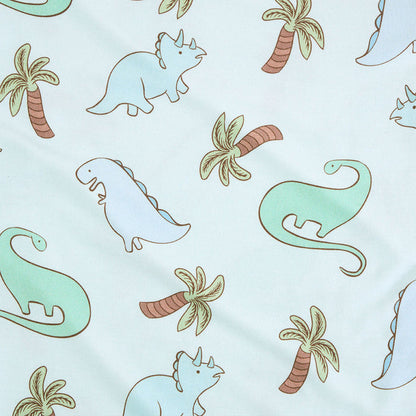 closeup of print with dinosaurs and palm trees on a blue background